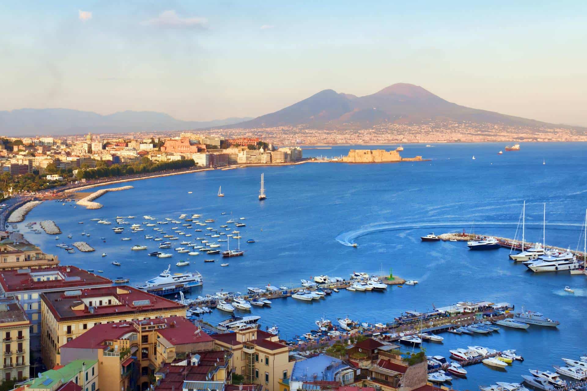 View of the port in the Gulf of Naples, the Egg Castle and Mount Vesuvius on a summer day.