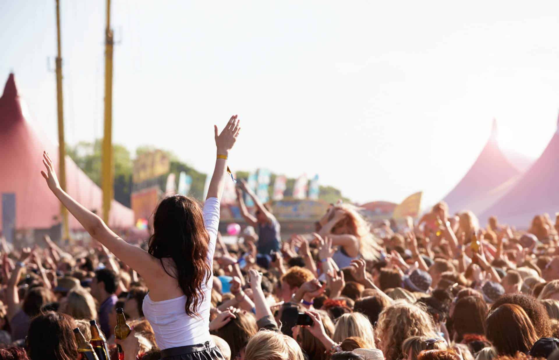 Crowd enjoying themselves at outdoor music festival.