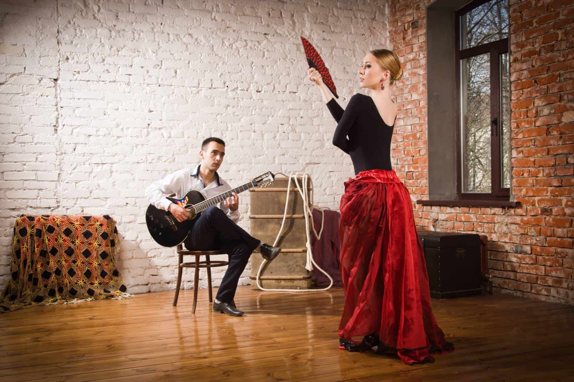 Young woman dancing flamenco and a man playing the guitar.