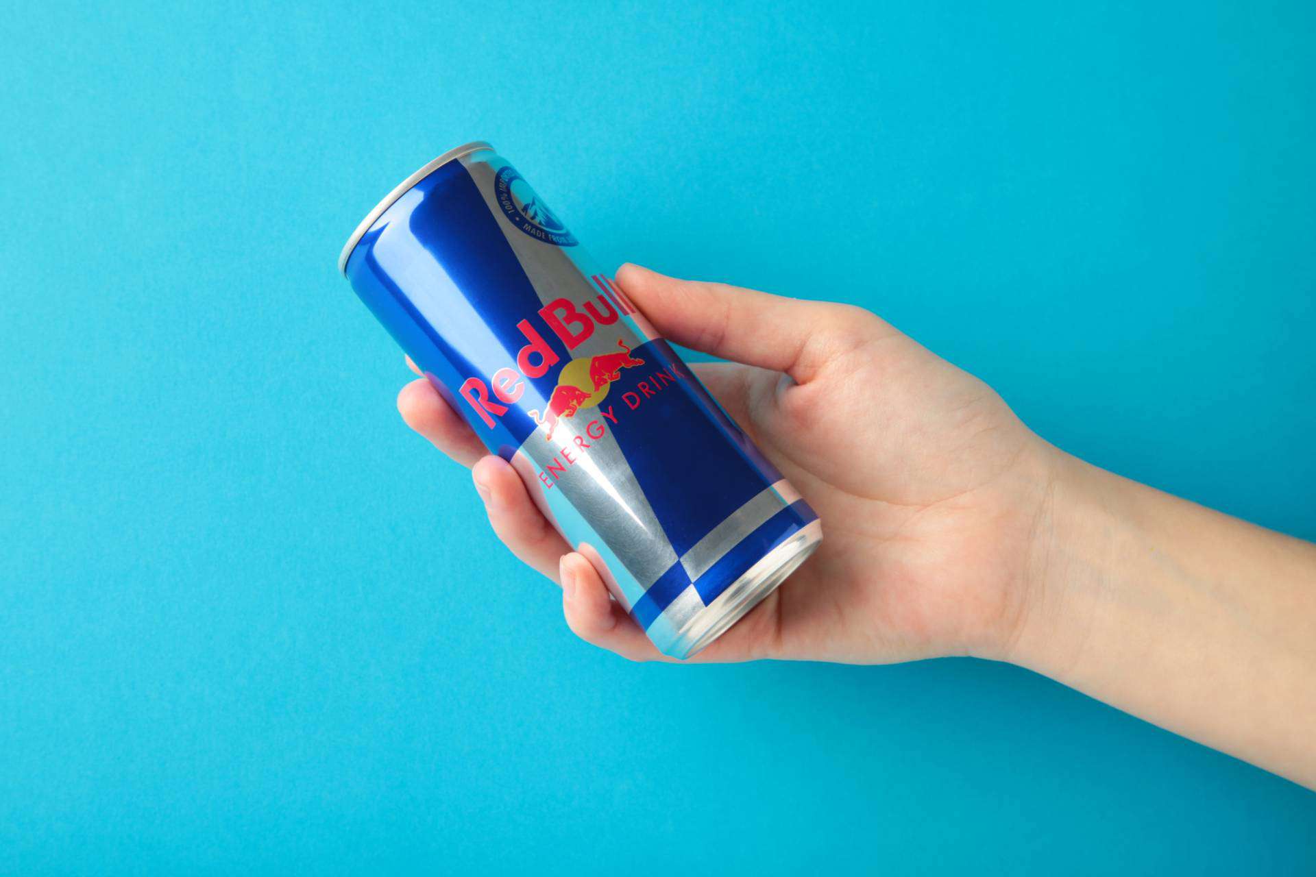 Hand holding a can of Red Bull energy drink