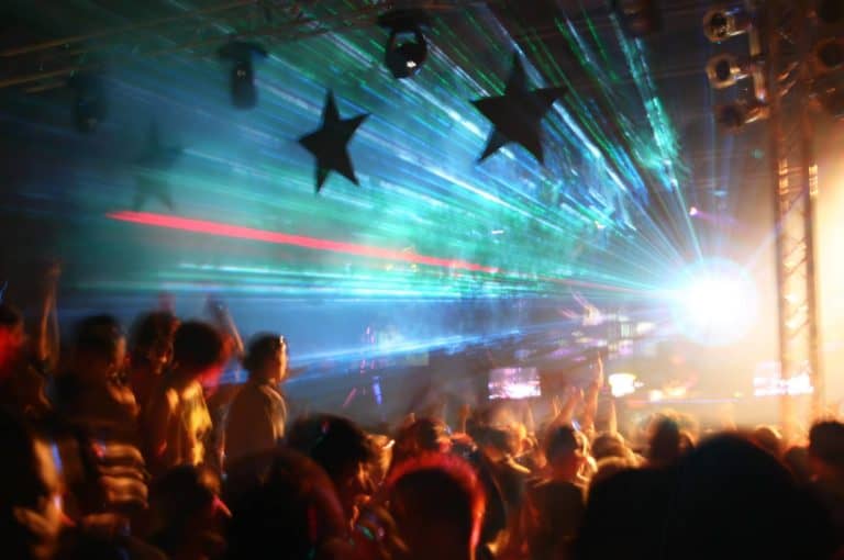Large clubbers party with young people, laser show and smoke.