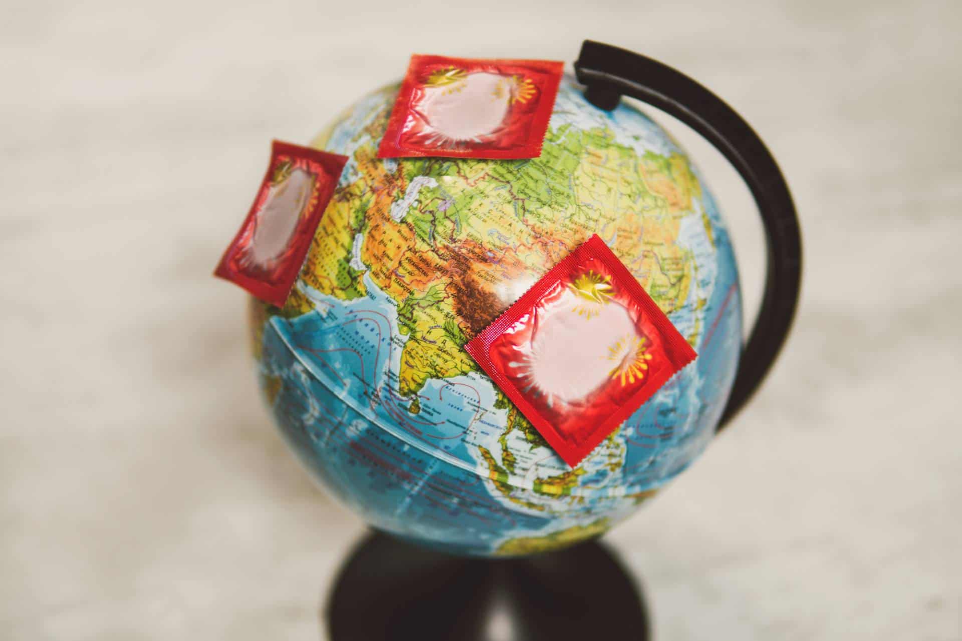 Packs of condoms on globe depicting global sex survey.