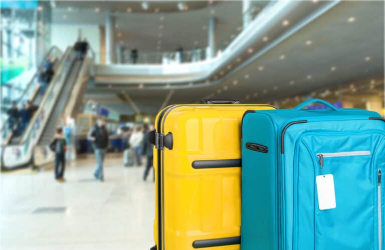yellow and blue suitcase standing in airport